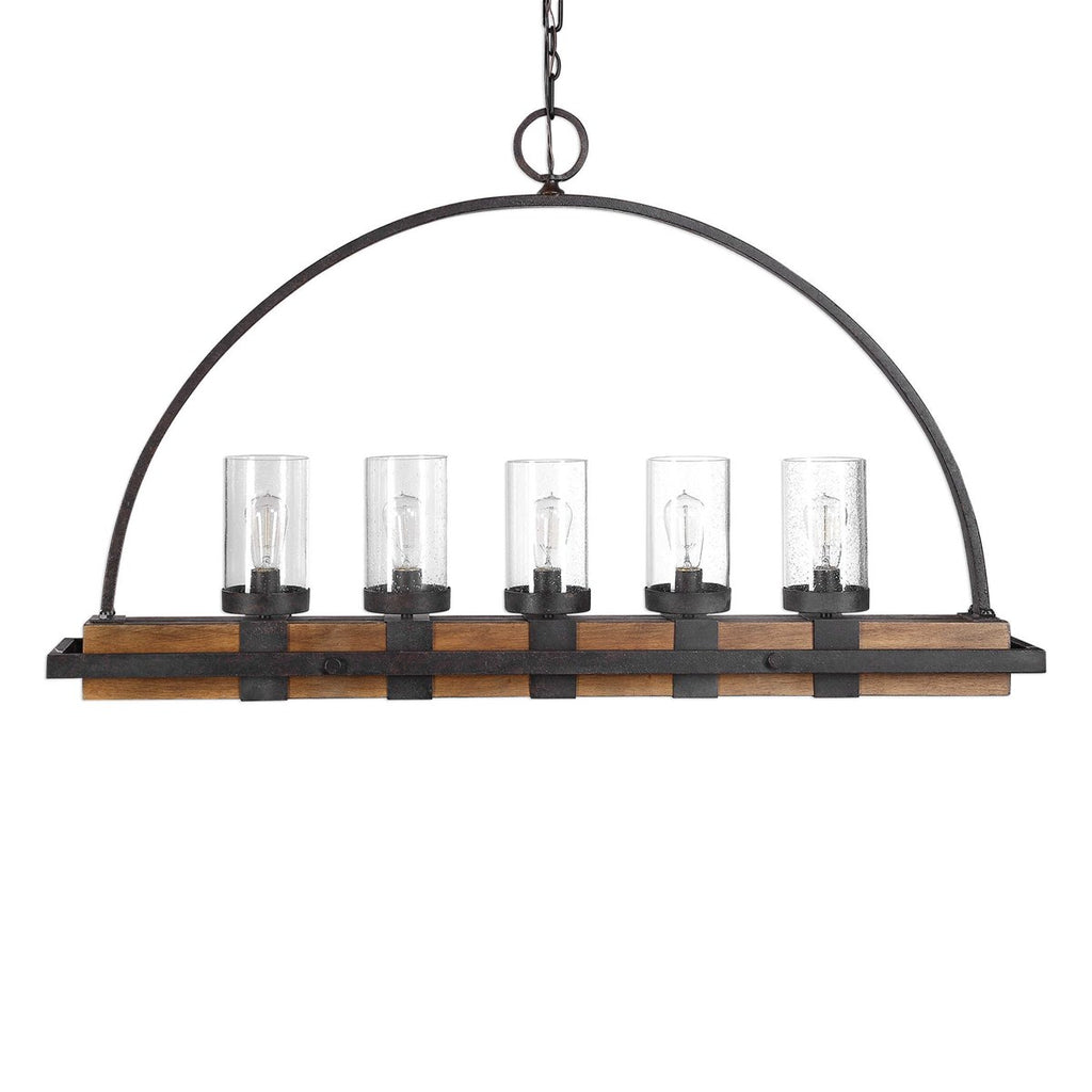 Atwood Hanging Island 5 Light Heavy gauge real wood linear body, finished in a mid-tone, featuring clear seeded glass shades. A nod to industrial design is found in the iron wrapped frame, and top arch. The metal work is in a deep weathered bronze finish with a slight texture and black antiquing.