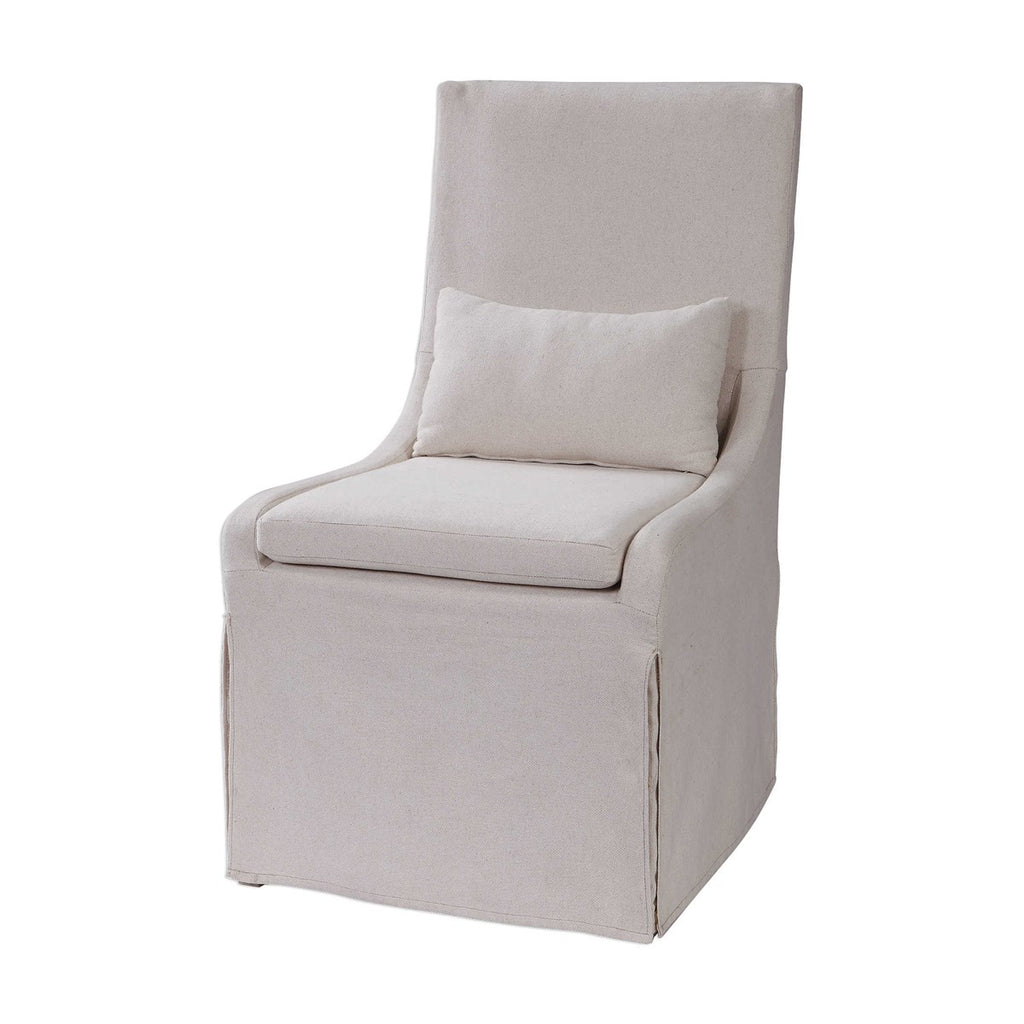 Front / Side View Coley Armless Linen Covered Tailored Chair by Uttermost. This chair is perfect for dining or accent chair. Simplistic in form, this casually sophisticated armless chair features a tailored off-white linen blend slipcover with a plush cushion seat and kidney pillow for added comfort.