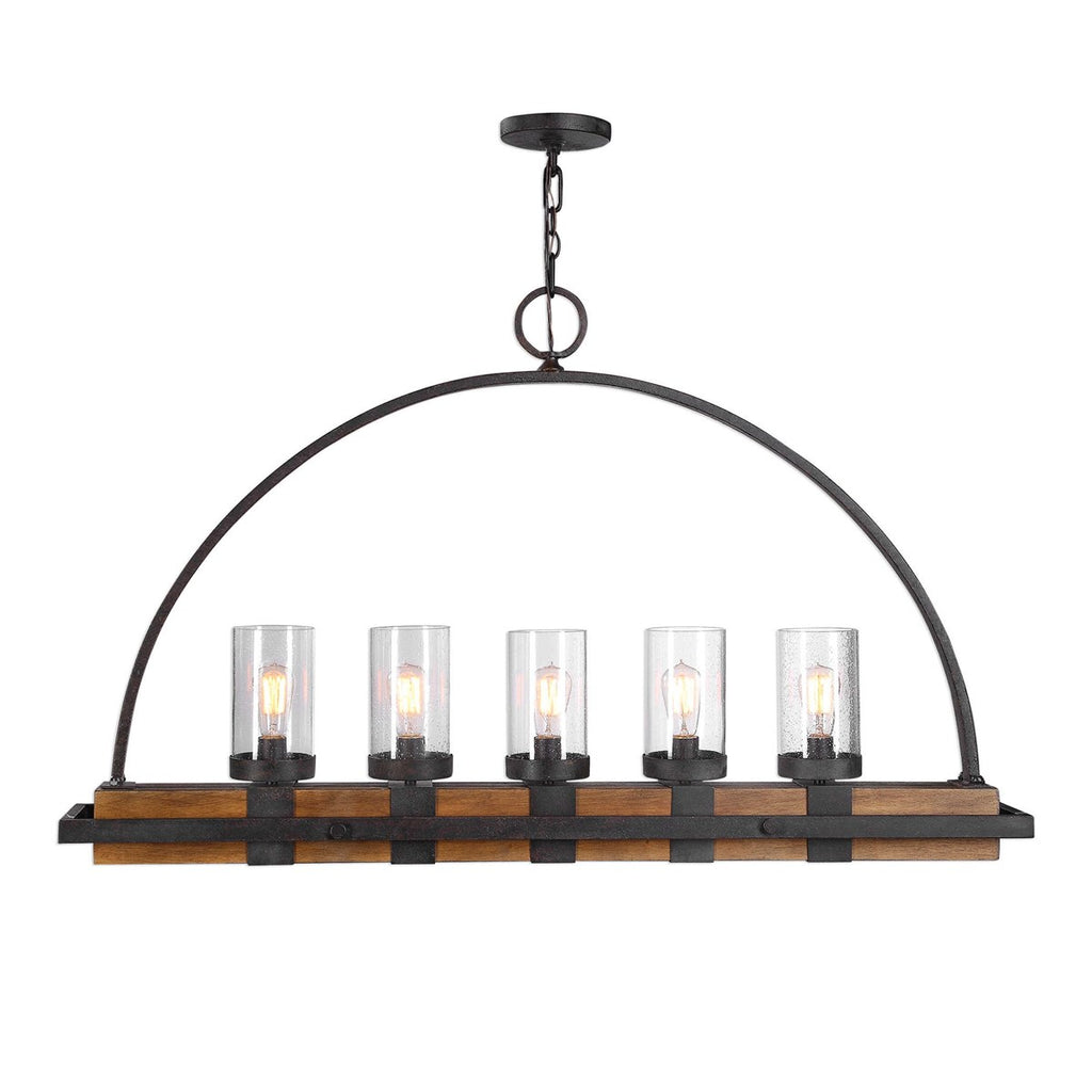 Atwood Hanging Island 5 Light Heavy gauge real wood linear body, finished in a mid-tone, featuring clear seeded glass shades. A nod to industrial design is found in the iron wrapped frame, and top arch. The metal work is in a deep weathered bronze finish with a slight texture and black antiquing. 