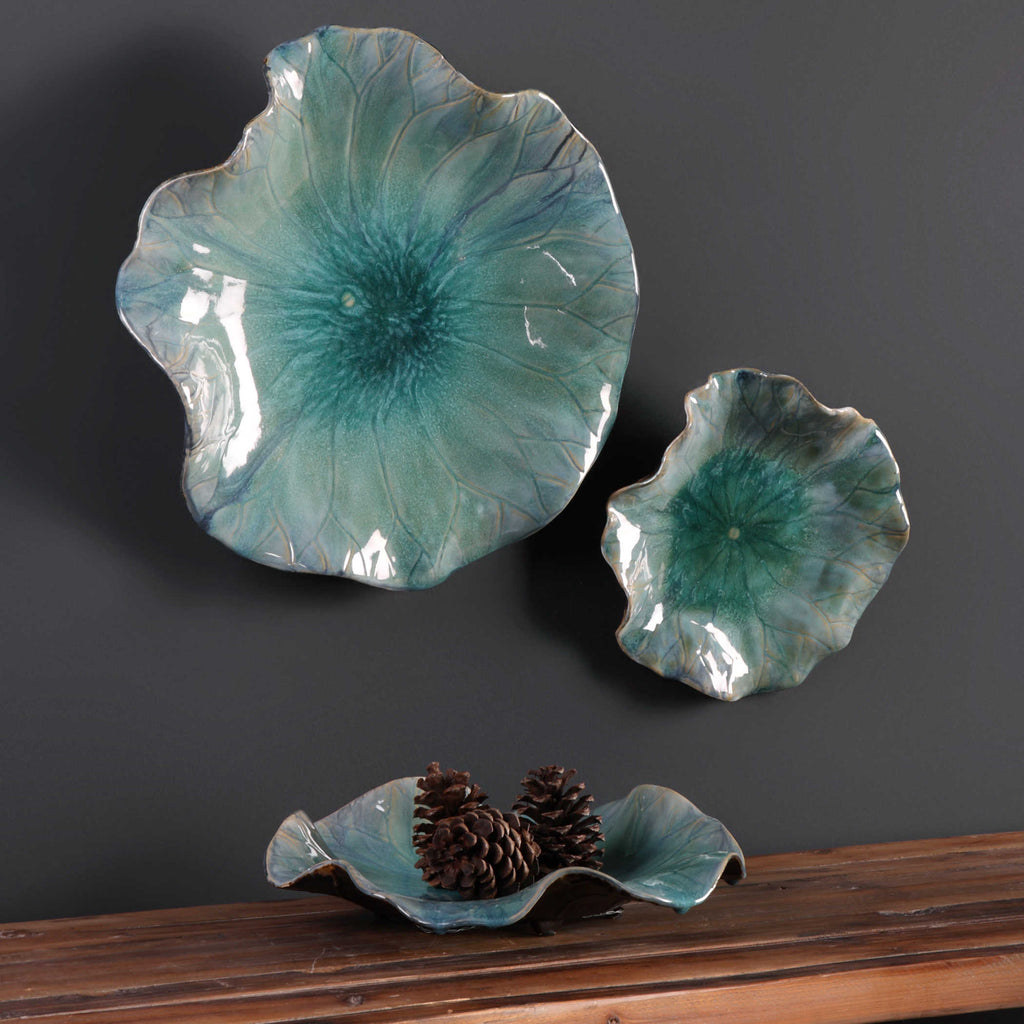 Set of 3 aqua ceramic flowers shown as wall decor or tabletop decor by Uttermost