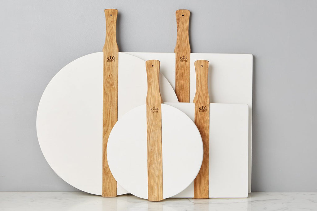 Large White Round Italia Charcuterie Board by etúHOME. Hand-crafted from reclaimed wood, this charcuterie board can also double as a decorative kitchen accent. Paired with square etúHOME board collection shown in large and small.