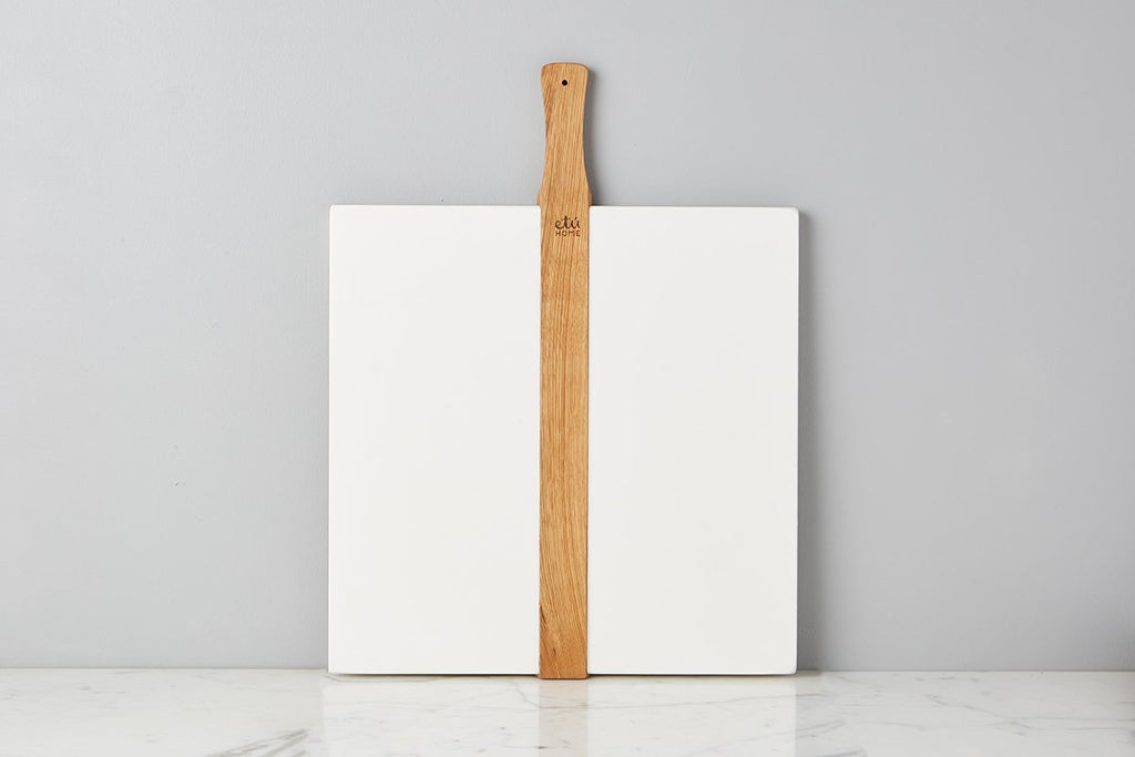 Large or small white square Italian charcuterie board. Hand-crafted from reclaimed wood, this charcuterie board’s modern yet functional design can also double as a decorative kitchen accent.  Front view with wood detail.